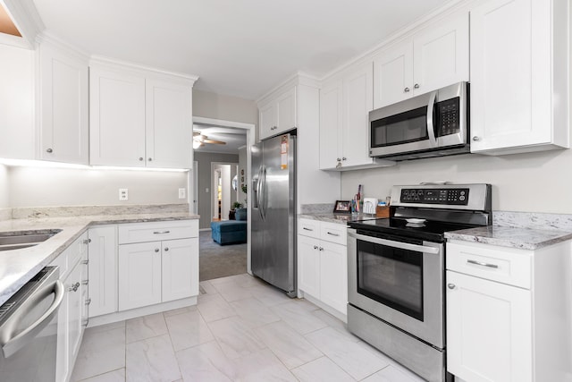 kitchen featuring ceiling fan, white cabinets, appliances with stainless steel finishes, and light stone countertops