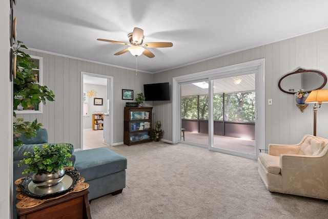 living room with ceiling fan, light colored carpet, and ornamental molding