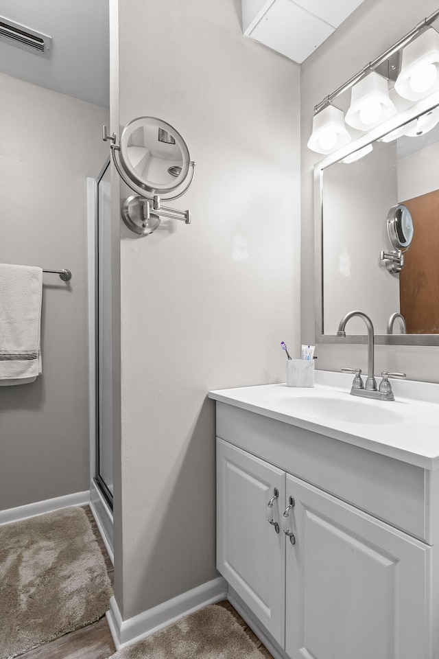 bathroom featuring wood-type flooring, vanity, and a shower with door