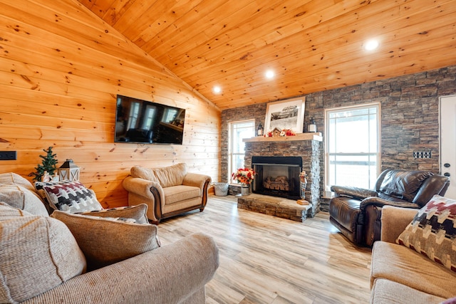 living room featuring wooden ceiling, a stone fireplace, wood walls, and light hardwood / wood-style flooring