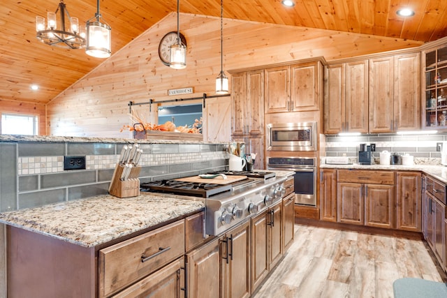 kitchen featuring stainless steel appliances, lofted ceiling, and a barn door