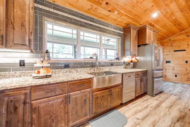 kitchen featuring sink, light wood-type flooring, stainless steel appliances, and decorative backsplash