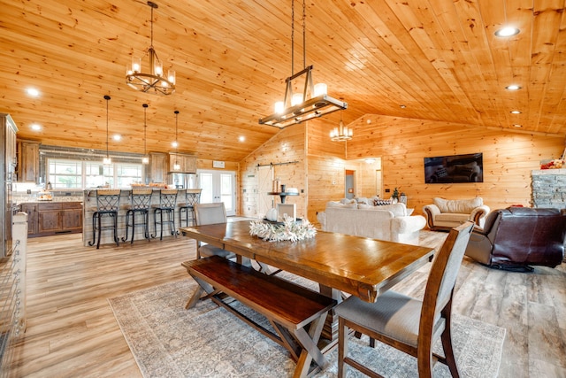 dining space featuring wood ceiling, wood walls, high vaulted ceiling, a notable chandelier, and light hardwood / wood-style floors