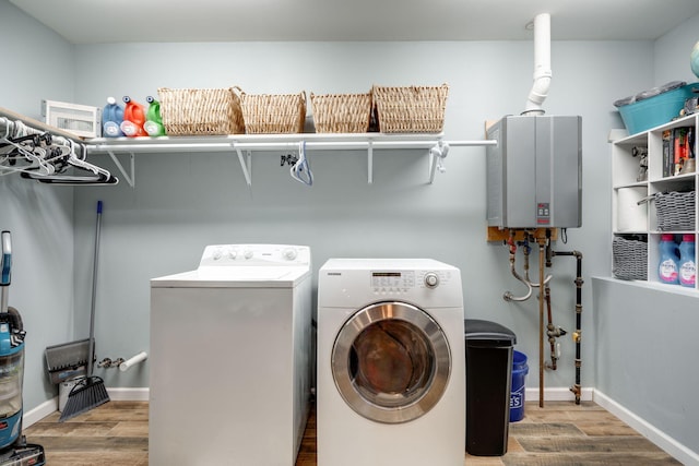 laundry area with wood-type flooring, water heater, and separate washer and dryer