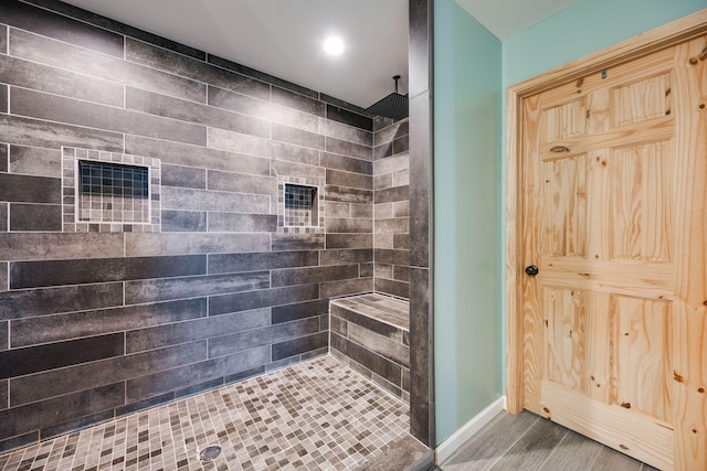 bathroom featuring wood-type flooring and tiled shower