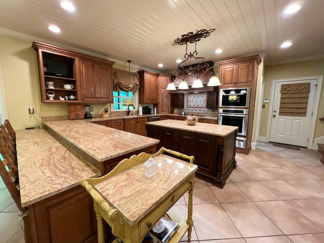 kitchen with sink, hanging light fixtures, a kitchen island, kitchen peninsula, and a breakfast bar area