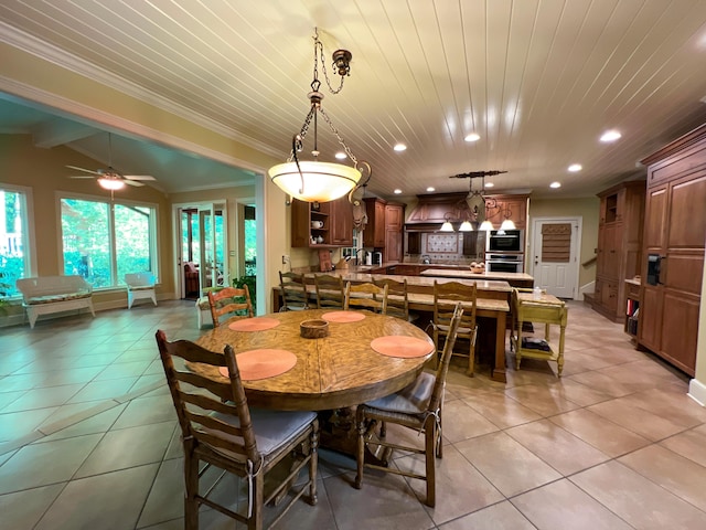 tiled dining area with ceiling fan, lofted ceiling with beams, and ornamental molding