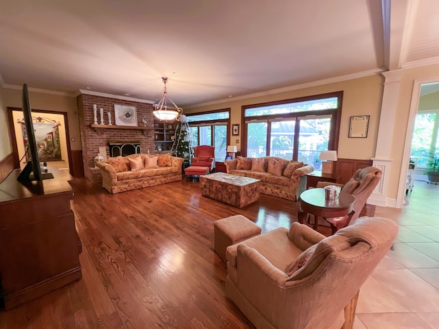 tiled living room featuring a fireplace, a wealth of natural light, and ornamental molding