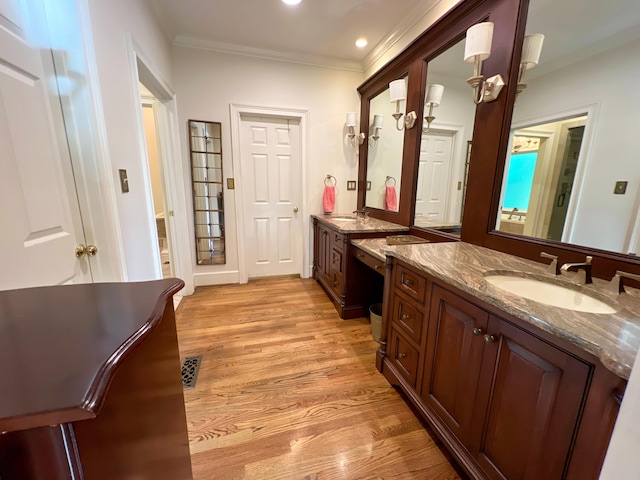 bathroom featuring hardwood / wood-style floors, vanity, and ornamental molding