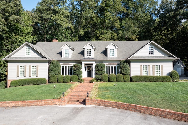 cape cod home featuring a front lawn