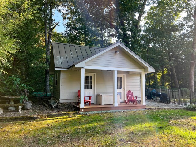 view of outdoor structure featuring covered porch and a yard