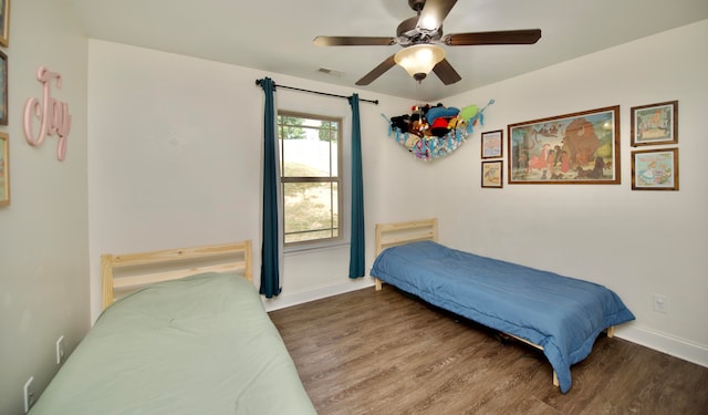 bedroom with ceiling fan and dark wood-type flooring