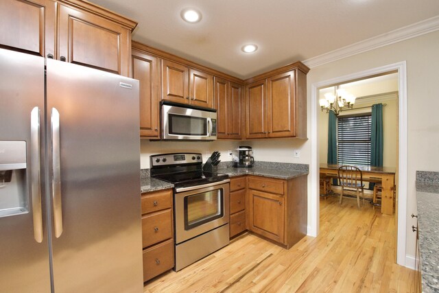 kitchen with ornamental molding, stainless steel appliances, light wood-type flooring, and a chandelier