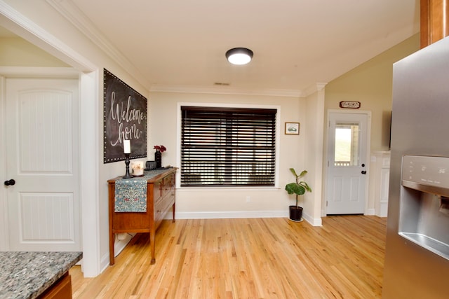 foyer entrance with light wood-type flooring and crown molding