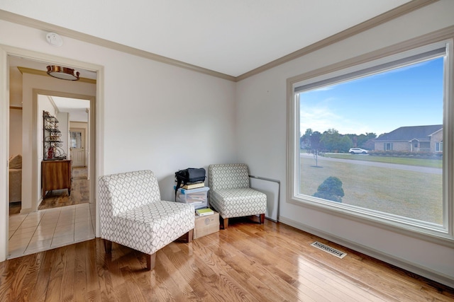 sitting room featuring wood-type flooring and ornamental molding