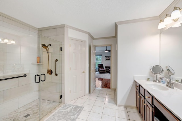 bathroom featuring ceiling fan, vanity, ornamental molding, tile patterned floors, and a shower with door