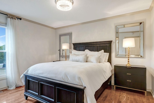 bedroom with ornamental molding and hardwood / wood-style flooring