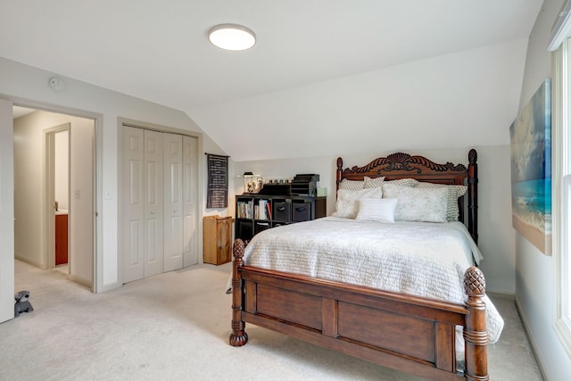 bedroom with vaulted ceiling, light colored carpet, and a closet