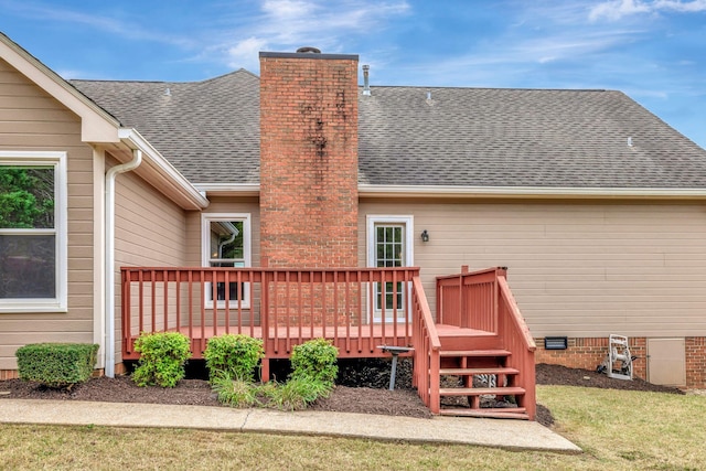 back of property with a wooden deck and a lawn