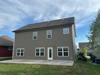 rear view of house featuring a lawn and a patio