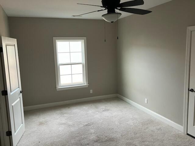 unfurnished room featuring ceiling fan and light colored carpet