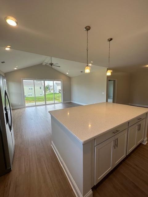 kitchen featuring pendant lighting, dark wood-type flooring, lofted ceiling, white cabinetry, and ceiling fan