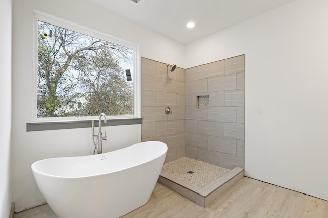 bathroom featuring independent shower and bath and hardwood / wood-style flooring