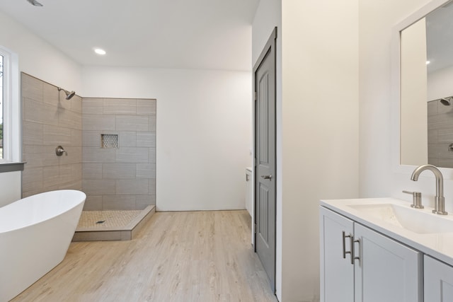 bathroom with vanity, plus walk in shower, and hardwood / wood-style flooring