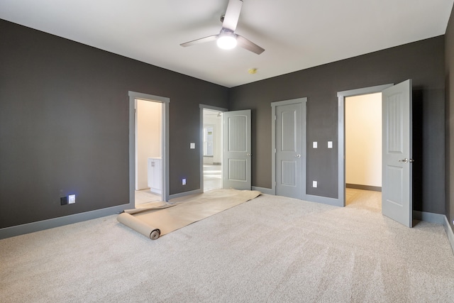 unfurnished bedroom with connected bathroom, ceiling fan, and light carpet