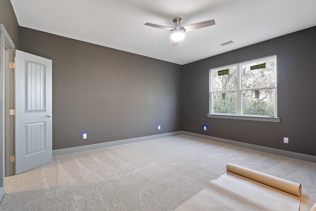 carpeted spare room featuring ceiling fan