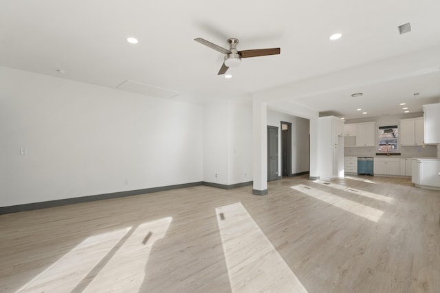 unfurnished living room with ceiling fan, light hardwood / wood-style floors, and sink