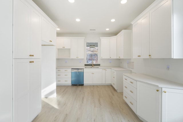 kitchen featuring dishwasher, white cabinetry, sink, and light hardwood / wood-style flooring