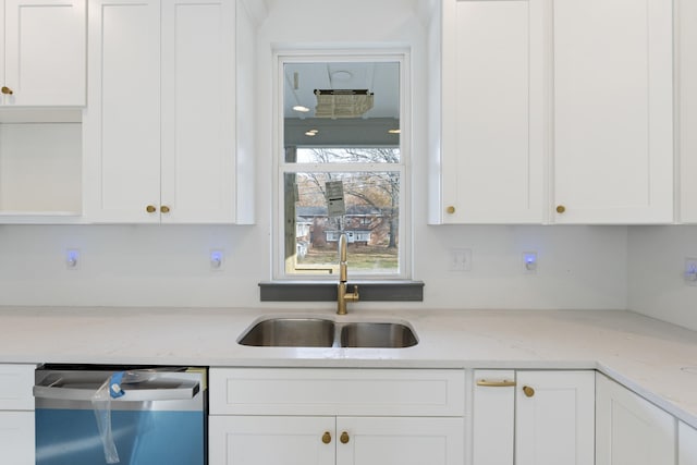 kitchen featuring dishwasher, white cabinetry, light stone countertops, and sink