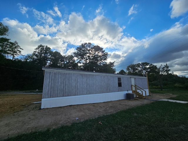 view of property exterior featuring a lawn and cooling unit