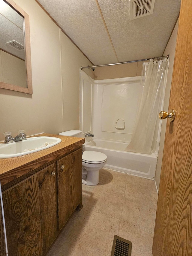 full bathroom with tile patterned flooring, a textured ceiling, shower / tub combo with curtain, vanity, and toilet