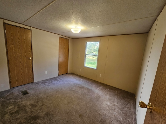 unfurnished bedroom with a textured ceiling and carpet flooring