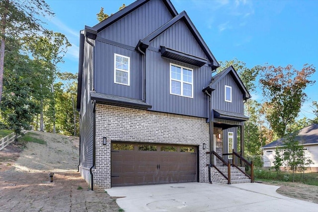 modern farmhouse featuring board and batten siding, concrete driveway, brick siding, and an attached garage