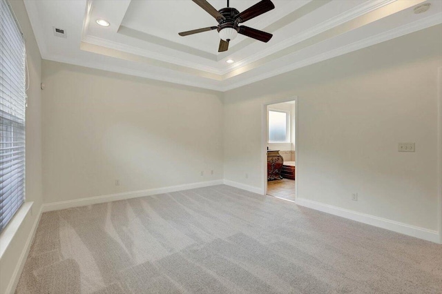 unfurnished room with ornamental molding, ceiling fan, a raised ceiling, and light carpet