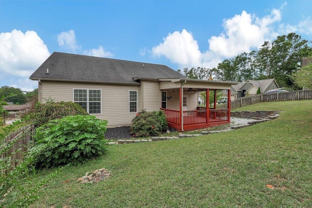 rear view of property featuring a deck and a yard