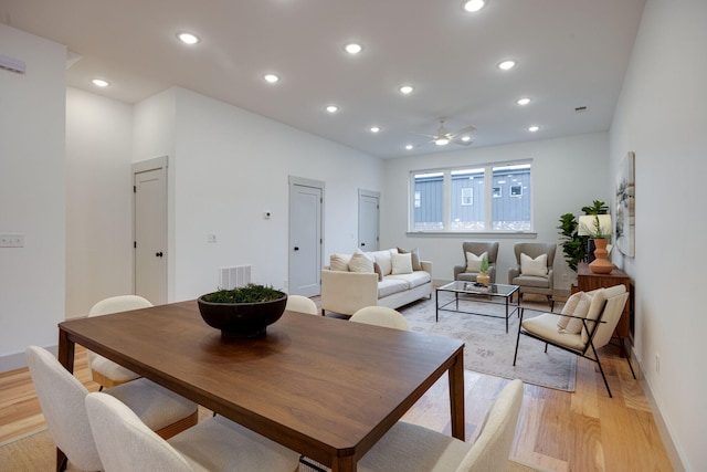 dining space with ceiling fan, visible vents, light wood-type flooring, and baseboards