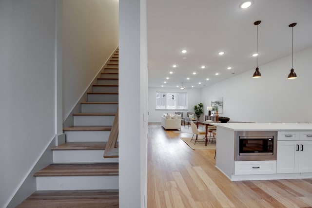staircase with recessed lighting and wood finished floors