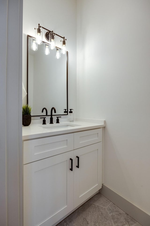 bathroom with baseboards, tile patterned flooring, and vanity