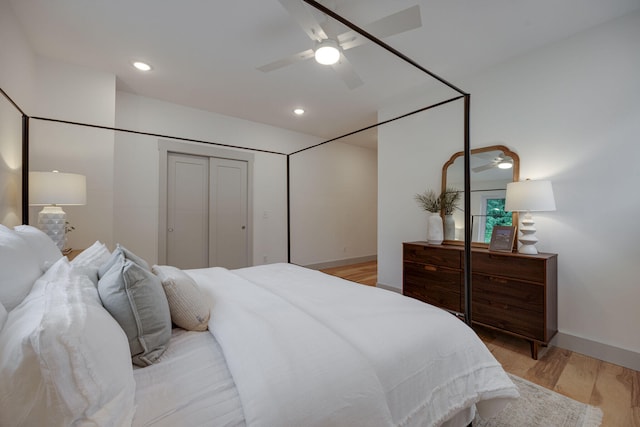 bedroom with ceiling fan, baseboards, and light wood-style floors
