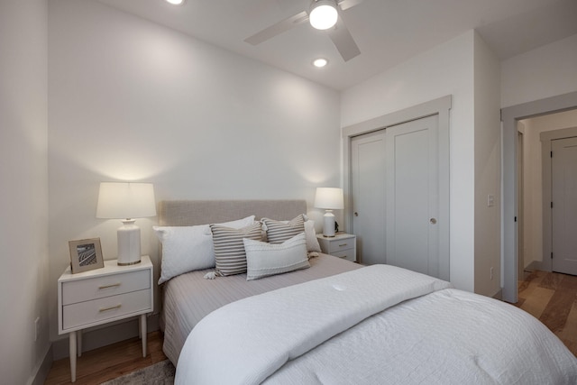 bedroom with wood finished floors, baseboards, recessed lighting, and a closet