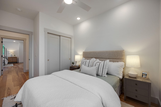 bedroom with wood finished floors, ceiling fan, recessed lighting, and a closet