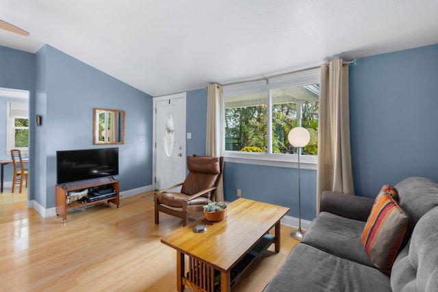 living room with light wood-type flooring and vaulted ceiling