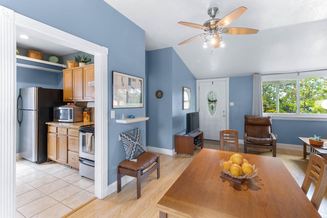 dining space with light wood-type flooring, vaulted ceiling, and ceiling fan