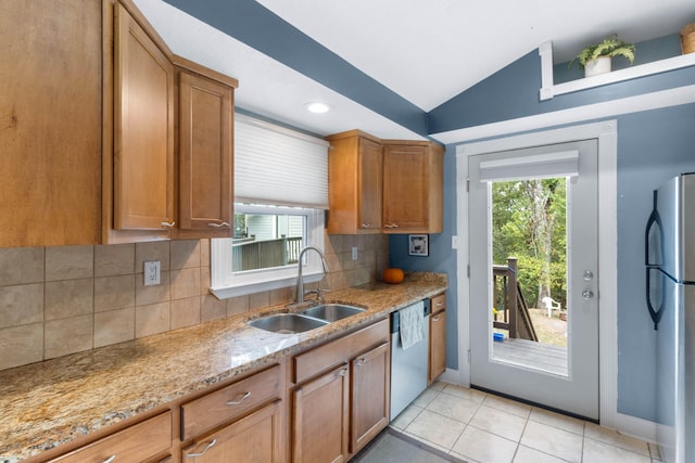 kitchen featuring stainless steel appliances, a wealth of natural light, light tile patterned floors, and sink