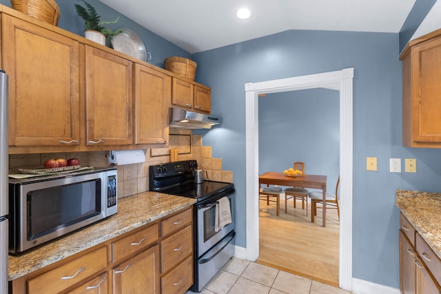 kitchen with light stone countertops, lofted ceiling, electric range, and light tile patterned floors