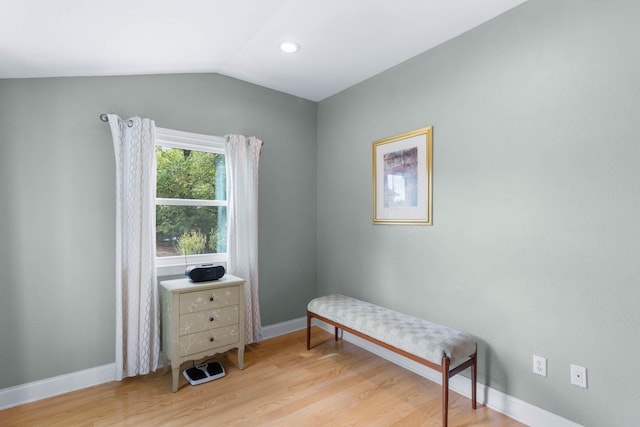 sitting room with light wood-type flooring and vaulted ceiling